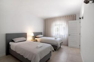 - une chambre avec 2 lits et une fenêtre dans l'établissement Encosta do Lago - With Private Pool, à Quinta do Lago