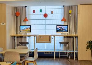 舟山的住宿－舟山定海智選假日酒店，客房设有2张桌子和椅子以及大窗户。