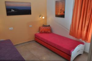 czerwona kanapa siedząca w rogu pokoju w obiekcie Mory's Place - Luxurious Holiday Apartment w mieście Arad