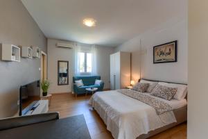 1 dormitorio con 1 cama grande y 1 silla azul en Sara Residence, en Zadar