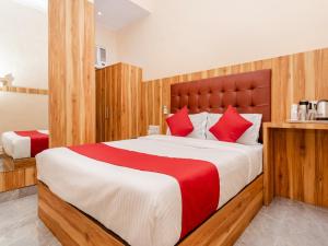 a bedroom with a large bed with red pillows at Hotel Al Moazin in Mumbai +65 photos