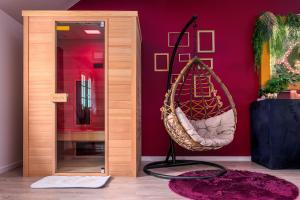 um quarto com uma cadeira suspensa e um espelho em Suite L'echappee - Maison romantique - SPA & Sauna Privatif- Pole Dance - Lit rond avec miroir au plafond em Pézarches