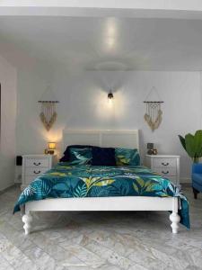 a bedroom with a white bed and two night stands at Appart adorable proche de la baie orientale, Idolem résidence unité 2 - 57 Rue du Mont Vernon 1 in Cul de Sac