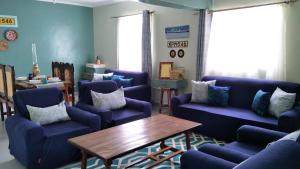 a living room with blue couches and a wooden table at Kwetu Home - Sagana PAY BEFORE ARRIVAL in Sagana