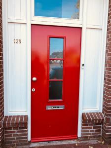 a red door on a brick house at Comfortable Room in Alkmaar