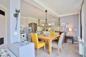 comedor y cocina con mesa de madera y sillas amarillas en Ferienbungalow Erlenweg 20 Erlenweg 20 Appartement 1 Niendorf Ostsee, en Niendorf