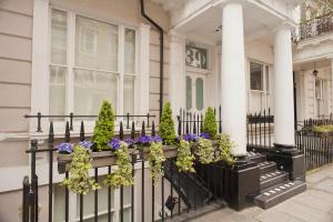 une maison blanche avec des fleurs sur une clôture dans l'établissement 39 Studios, à Londres