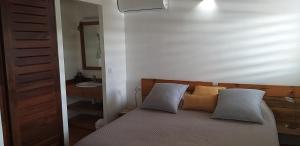 a bedroom with a bed with two pillows on it at VILLA TOCADE in Saint-François +25 photos