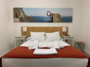 a bedroom with a large bed with white pillows at Pensión Amara in Donostia-San Sebastián +35 photos