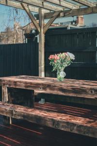 wazon kwiatów siedzący na drewnianej ławce w obiekcie Allangrange Hotel near Inverness w mieście Munlochy