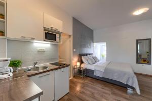 1 dormitorio con 1 cama y cocina con fregadero en Sara Residence en Zadar