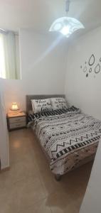 een bed in een kamer met een lamp en een bed sidx sidx sidx bij יחידת דיור in Rishon LeẔiyyon