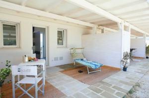 a patio with a bench and a table and chairs at Stabilimento Lido Burrone in Favignana