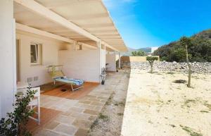 a white house with a bench under a roof at Stabilimento Lido Burrone in Favignana