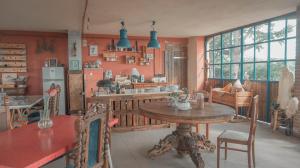 a dining room with a table and a kitchen at B&B La Buonora in Sinio