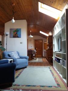 sala de estar con sofá azul y techo de madera en B&B In Mansarda, en Muzzano