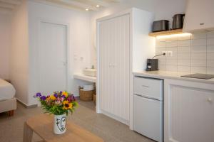 a kitchen with a vase of flowers on a table at Skepi Town Houses in Mýkonos City +60 photos