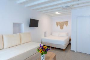 uma sala de estar branca com um sofá e uma cama em Skepi Town Houses em Míconos