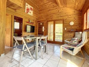a dining room with a table and chairs in a cabin at Chalet grand jardin, au calme, proche commerces in La Canourgue