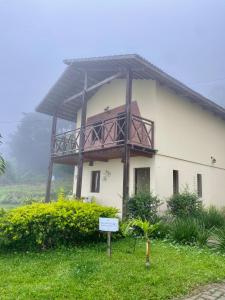 a house with a balcony on the side of it at Chalé Bela Vista - Chalés Belo Monte in Pacoti