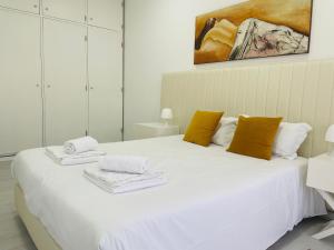 a bedroom with a white bed with towels on it at Dom Quixote apartamentos turísticos in Praia de Mira +63 photos