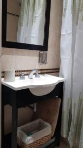 ein Bad mit einem Waschbecken und einem Spiegel in der Unterkunft Gurruchaga Suites free parking Movistar Outlet in Buenos Aires