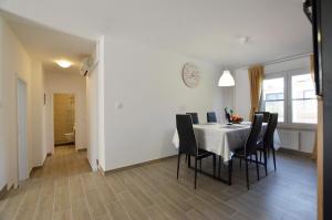 una sala da pranzo con tavolo bianco e sedie nere di Katy Apartment a Rovigno (Rovinj)