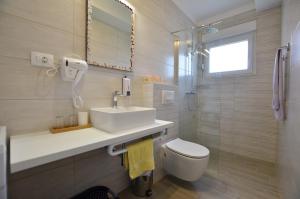 łazienka z umywalką, toaletą i lustrem w obiekcie Katy Apartment w Rovinj +21 zdjęć