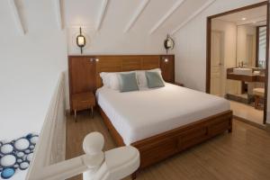 a hotel room with a bed and a dresser at Centara Grand Island Resort & Spa in Machchafushi