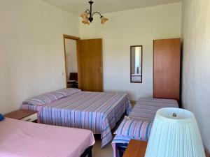 ein Hotelzimmer mit 2 Betten und einem Spiegel in der Unterkunft Il soggiorno diVino in Cirò Marina