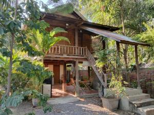 ein Haus im Wald mit einer Veranda und einer Treppe in der Unterkunft O'hamok family in Battambang