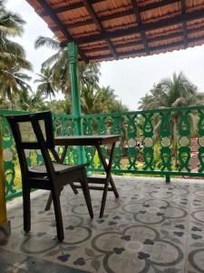 a chair sitting on a balcony with a fence at Villa Agastya in Betalbatim