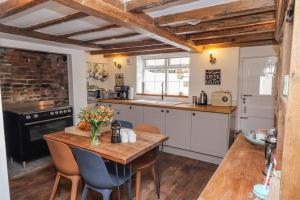 a kitchen with a wooden table and a stove top oven at Anchor Cottage in Whitby