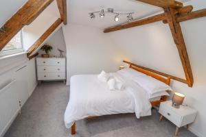 a bedroom with a bed with white sheets at Anchor Cottage in Whitby