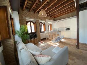 uma sala de estar com um sofá e uma cozinha em Hostfy Centro, Puerta Osario em Sevilha