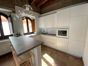 uma cozinha com armários brancos e um balcão preto em Hostfy Centro, Puerta Osario em Sevilha