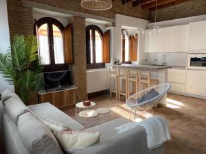 uma sala de estar com um sofá e uma cozinha em Hostfy Centro, Puerta Osario em Sevilha