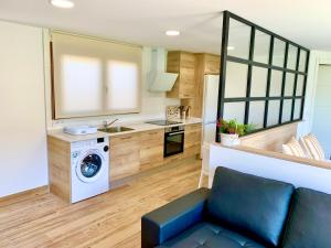 een keuken en een woonkamer met een wasmachine en droger bij Apartamento El Pedregal BAJO con jardin in Noja
