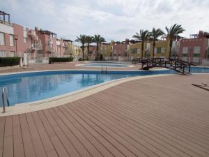 a swimming pool in a city with palm trees and buildings at ATICO LAGUNA BEACH con JACUZZY PRIVADO in Vera