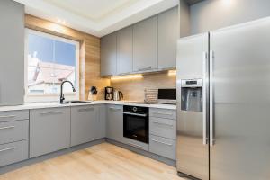 a kitchen with stainless steel appliances and a window at Holiday House Mewa by Renters in Międzywodzie