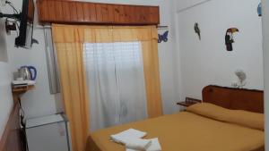 1 dormitorio con 1 cama y una ventana con cortinas en Hotel Brisas Marinas en San Clemente del Tuyú