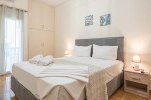 biała sypialnia z dużym łóżkiem i białymi poduszkami w obiekcie Elegant Home in Quiet Street by Cloudkeys w Atenach