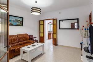 a living room with a leather couch and a table at Cas Llimoner in Palma de Mallorca