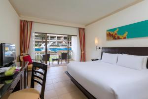ein Hotelzimmer mit einem großen Bett und einem Esszimmer in der Unterkunft Centara Kata Resort Phuket in Kata Beach + 37 Fotos