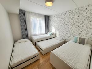 Habitación pequeña con 2 camas y ventana en City Center Bright Home, en Tallin