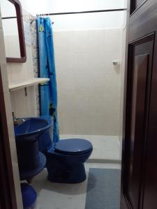 uma casa de banho com 2 WC azuis e um chuveiro em Hostal La Comedia em Jardín