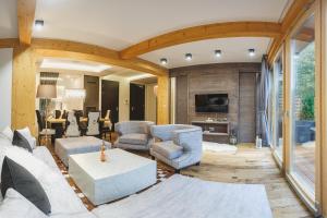 ein Wohnzimmer mit einem Sofa, Stühlen und einem Tisch in der Unterkunft VisitZakopane - Good Vibe Spa Apartment in Zakopane