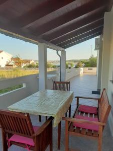 een tafel en 2 stoelen op een patio met uitzicht bij Apartments Donadic III, Caska in Novalja