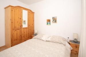1 dormitorio con 1 cama y armario de madera en MG Holiday Home, en Dubravice