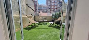 a balcony with chairs and grass outside a window at Atico Sagrada Familia in Barcelona